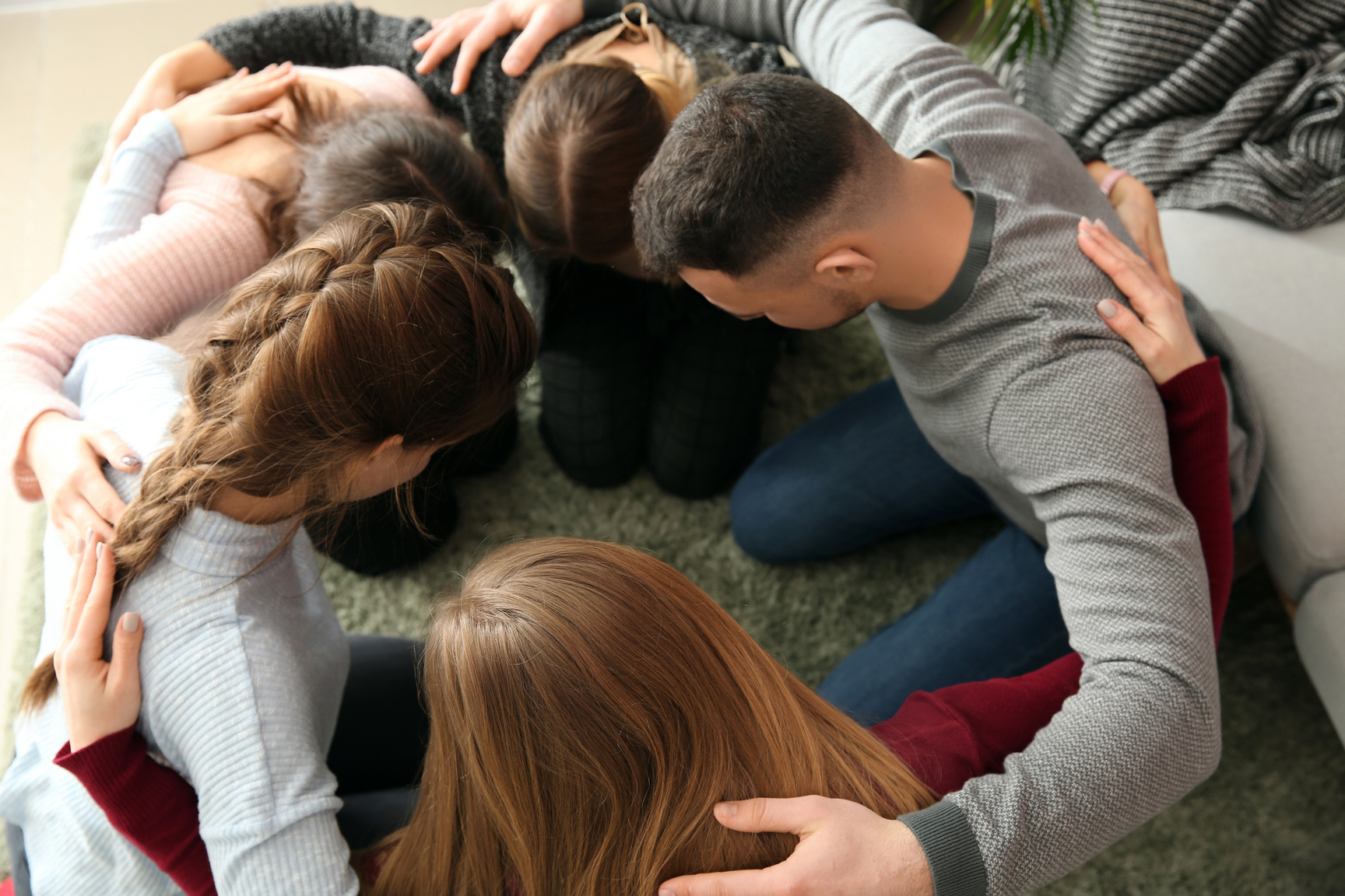 Group of People Praying Together Indoors